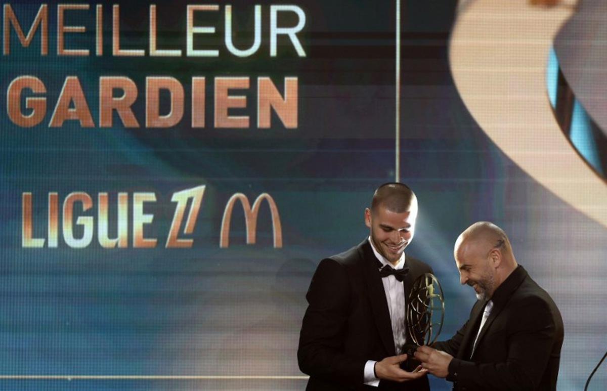 LOSC Lille's French goalkeeper Lucas Chevalier reacts as he receives the French Ligue 1 football's Best Goalkeeper of the Season award presented by French goalkeeper Jeremy Janot, during the televised UNFP (French National Professional Football players Union) trophy ceremony, in Paris on May 11, 2025. FRANCK FIFE / AFP
