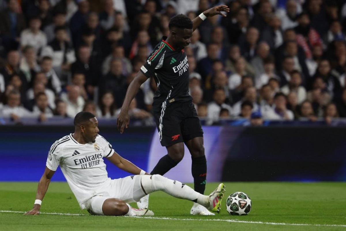 Real Madrid's Austrian defender #04 David Alaba and Arsenal's Ghanaian midfielder #05 Thomas Partey fight for the ball during the UEFA Champions League quarter final second leg football match between Real Madrid CF and Arsenal at Santiago Bernabeu Stadium in Madrid on April 16, 2025. Pierre-Philippe MARCOU / AFP