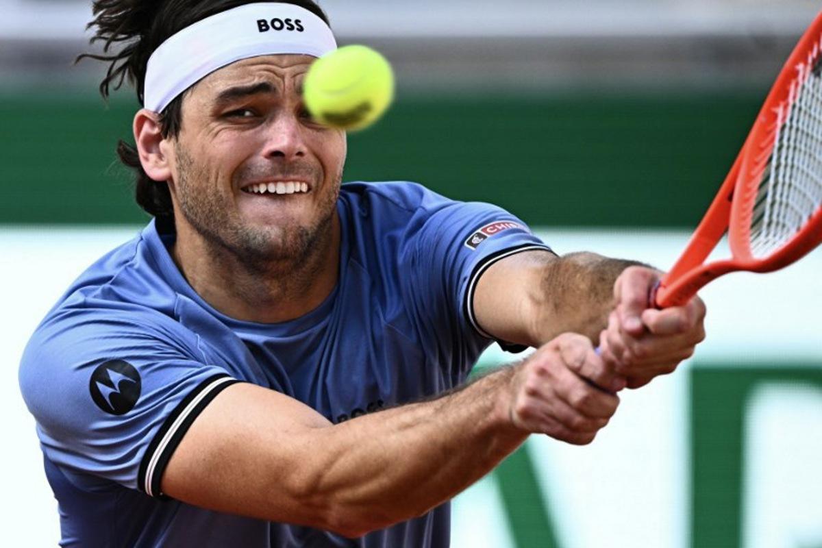 US Taylor Fritz plays a backhand return to US Nishesh Basavareddy during their men's singles match on day 1 of the French Open tennis tournament on Court Suzanne-Lenglen at the Roland-Garros Complex in Paris on May 24, 2026. JULIEN DE ROSA / AFP