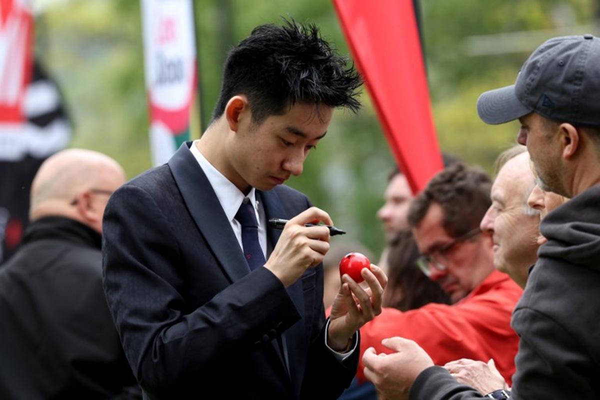 Chinese snooker player Wu Yize signs a snooker ball during a media day launching the start of the World Snooker Championship 2026 at Crucible Theatre in Sheffield, northern England, on April 17, 2026. Darren Staples / AFP