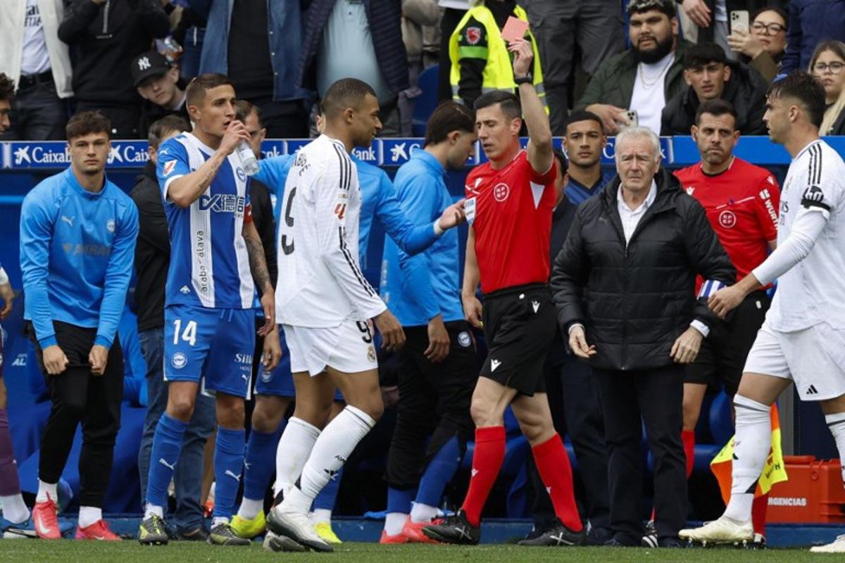 Real Madrid's French forward #09 Kylian Mbappe receives a red card from referee Cesar Soto during the Spanish league football match between Deportivo Alaves and Real Madrid CF at the Mendizorroza stadium in Vitoria on April 13, 2025. Ander GILLENEA / AFP