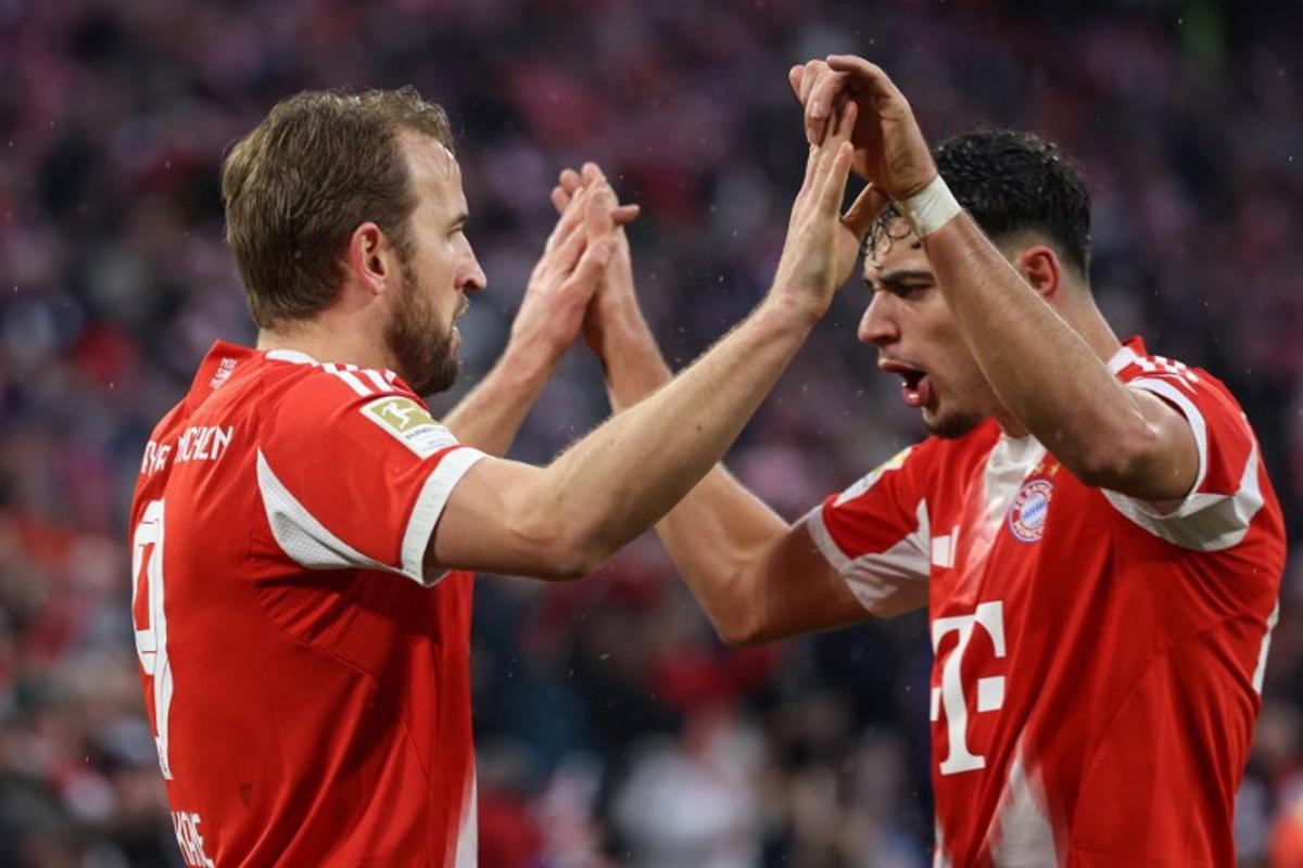 Bayern Munich's English forward #09 Harry Kane celebrates scoring the 3-0 goal with his teammate Bayern Munich's German midfielder #45 Aleksandar Pavlovic during the German first division Bundesliga football match between FC Bayern Munich and Eintracht Frankfurt in Munich, southern Germany, on February 21, 2026. Alexandra BEIER / AFP