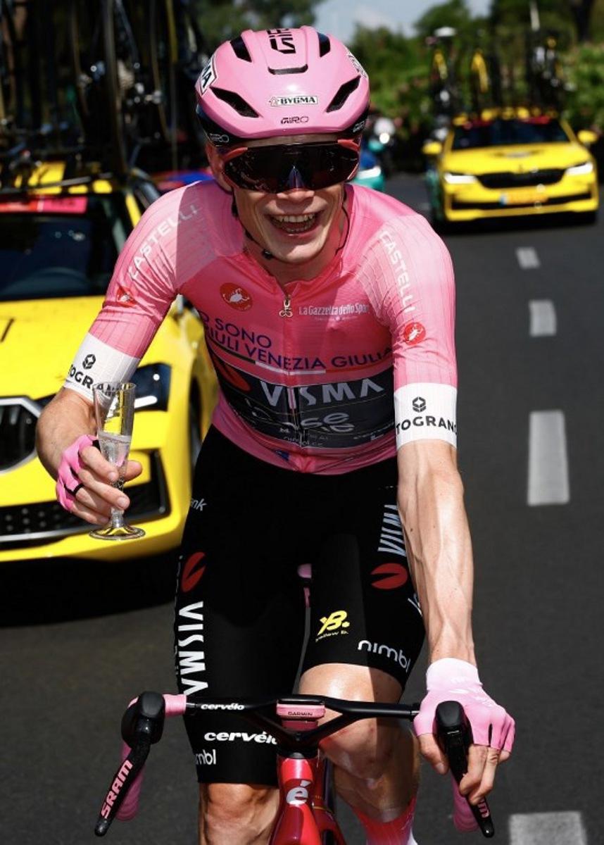 Team Visma Lease a Bike Danish rider Jonas Vingegaard wearing the overall leader's pink jersey holds a glass of sparkling wine during the 21th stage of the Giro d'Italia 2026 - Tour of Italy cycling race of 131km from Rome to Rome, Italy, on May 31, 2026. Luca Bettini / AFP