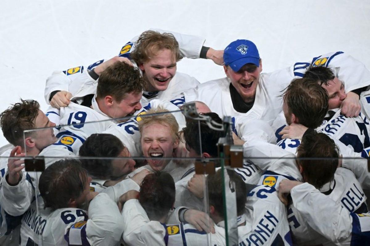 Finland's forward #94 Konsta Helenius (C) celebrates with teammates after scoring the sudden-death goal to win during the over time of the IIHF Ice Hockey Men's World Championship final match between Switzerland and Finland at the Swiss Life Arena in Zurich on May 31, 2026. SEBASTIEN BOZON / AFP