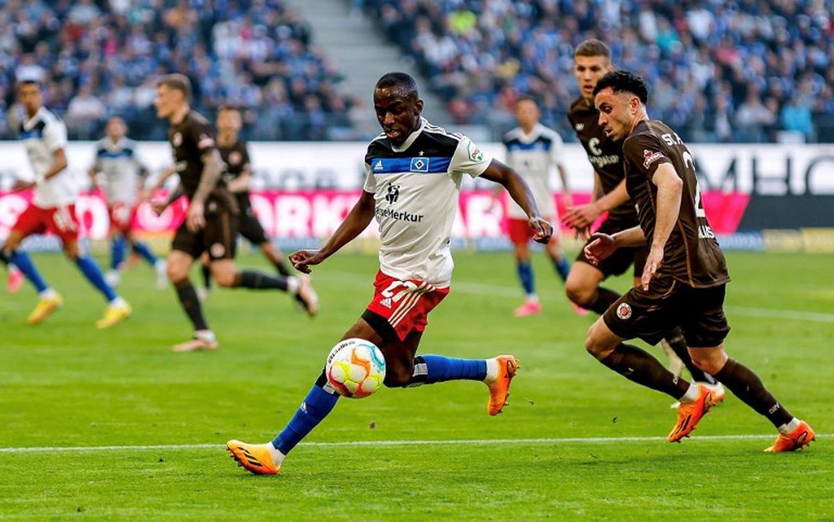 Hamburg's French forward Jean-Luc Dompe (L) and Sankt Pauli's Greek defender Manolis Saliakas vie for the ball during the second division football match Hamburger SV vs St Pauli in Hamburg on April 21, 2023. Axel Heimken / AFP