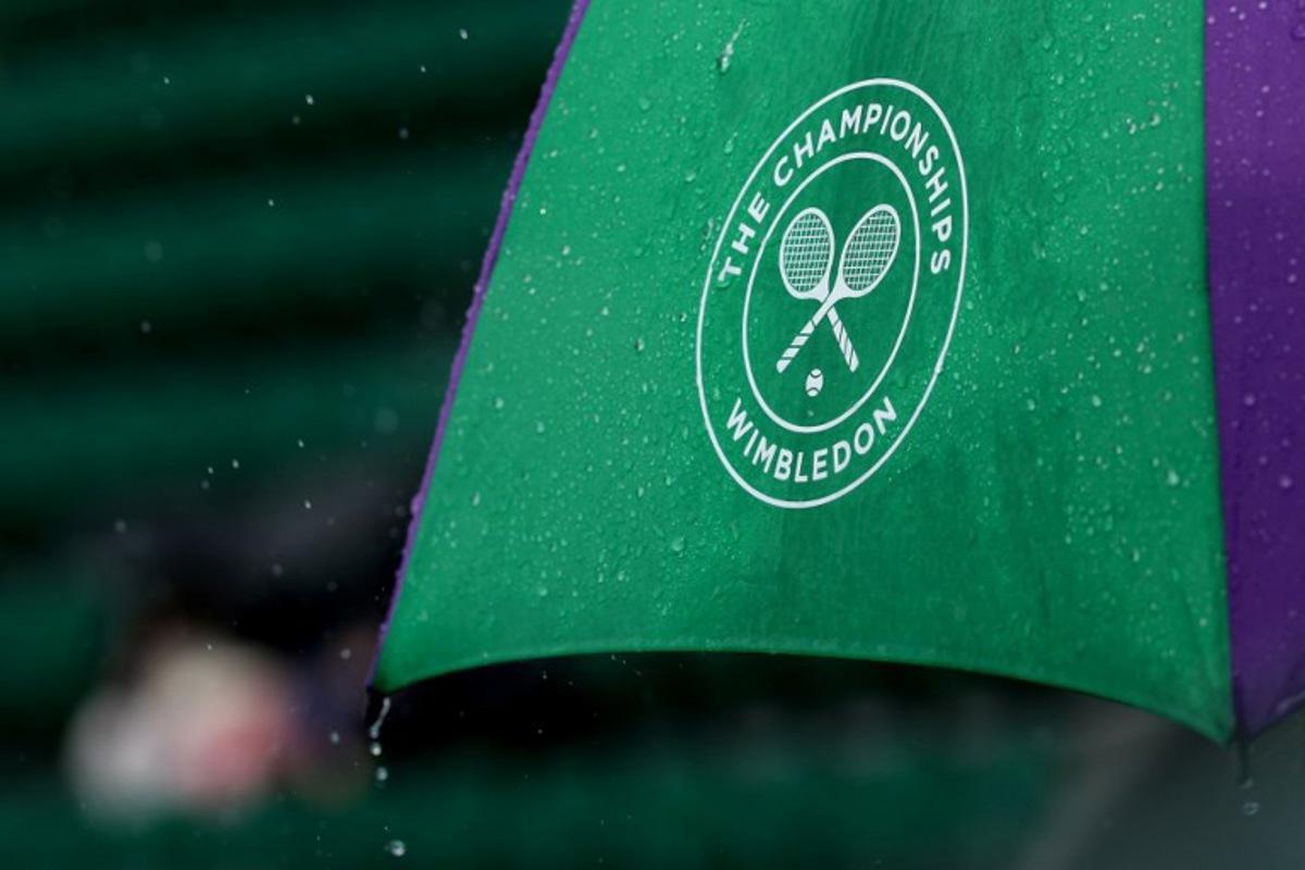 Rain falls from an umbrella on the seventh day of the 2025 Wimbledon Championships at The All England Lawn Tennis and Croquet Club in Wimbledon, southwest London, on July 6, 2025. Adrian Dennis / AFP