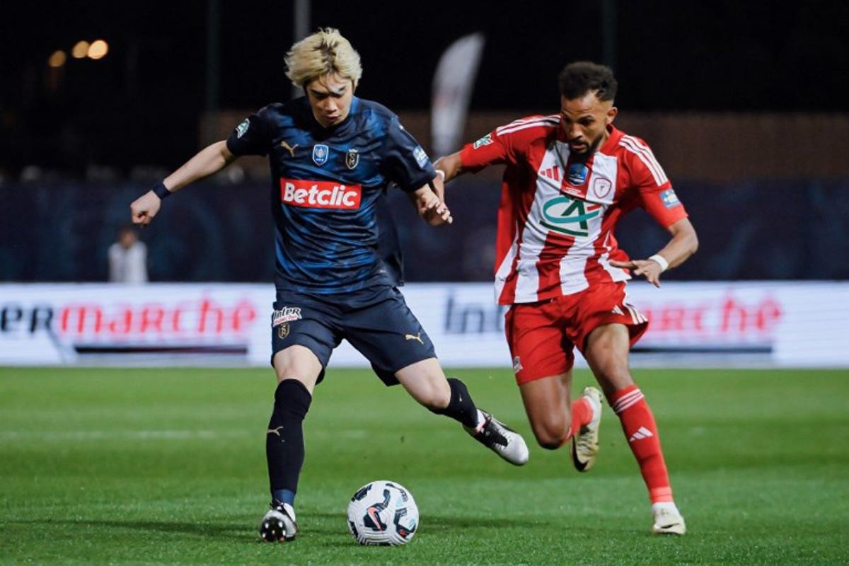 Reims' Japanese forward #07 Junya Ito (L) fights for the ball with AS Cannes' Mauritanian defender #27 Houssen Abderrahmane during the French Cup (Coupe de France) semi-final football match between AS Cannes and Stade de Reims at Pierre-de-Coubertin stadium in Cannes, southeastern France, on April 2, 2025. Frederic DIDES / AFP