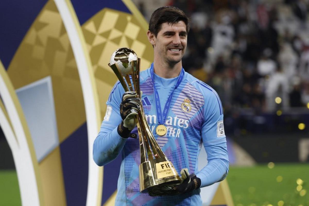 Real Madrid's Belgian goalkeeper #1 Thibaut Courtois poses with the tournament trophy during the podium ceremony after the 2024 FIFA Intercontinental Cup final football match between Spain's Real Madrid and Mexico's Pachuca at the Lusail Stadium in Doha on December 18, 2024. KARIM JAAFAR / AFP