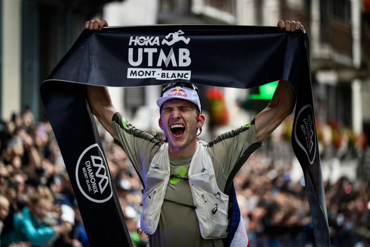 British Tom Evans celebrates as he crosses the finish line at the end of the 22nd edition of the Ultra Trail du Mont Blanc (UTMB), a 174km trail race crossing France, Italy and Switzerland, in Chamonix, south-eastern France on August 30, 2025. The Briton Tom Evans, 33 years old, won on August 30, 2025 the 22nd edition of the Ultra-Trail of Mont-Blanc in Chamonix (Haute-Savoie), following a grueling race marked by severe weather conditions and numerous dropouts. JEFF PACHOUD / AFP