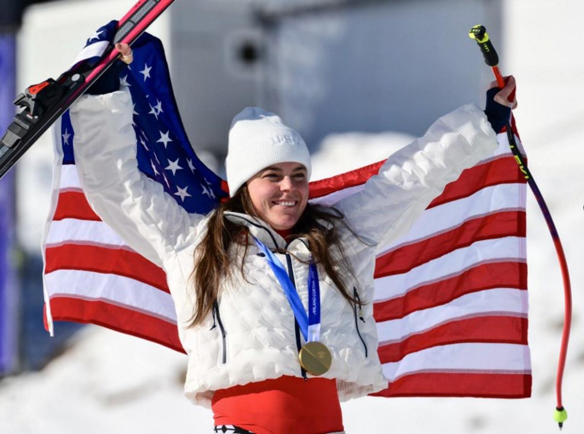 US' Breezy Johnson celebrates with her gold medal on the podium of the women's downhill event during the Milano Cortina 2026 Winter Olympic Games at the Tofane Alpine Skiing Centre in Cortina d'Ampezzo on February 8, 2026. Stefano RELLANDINI / AFP