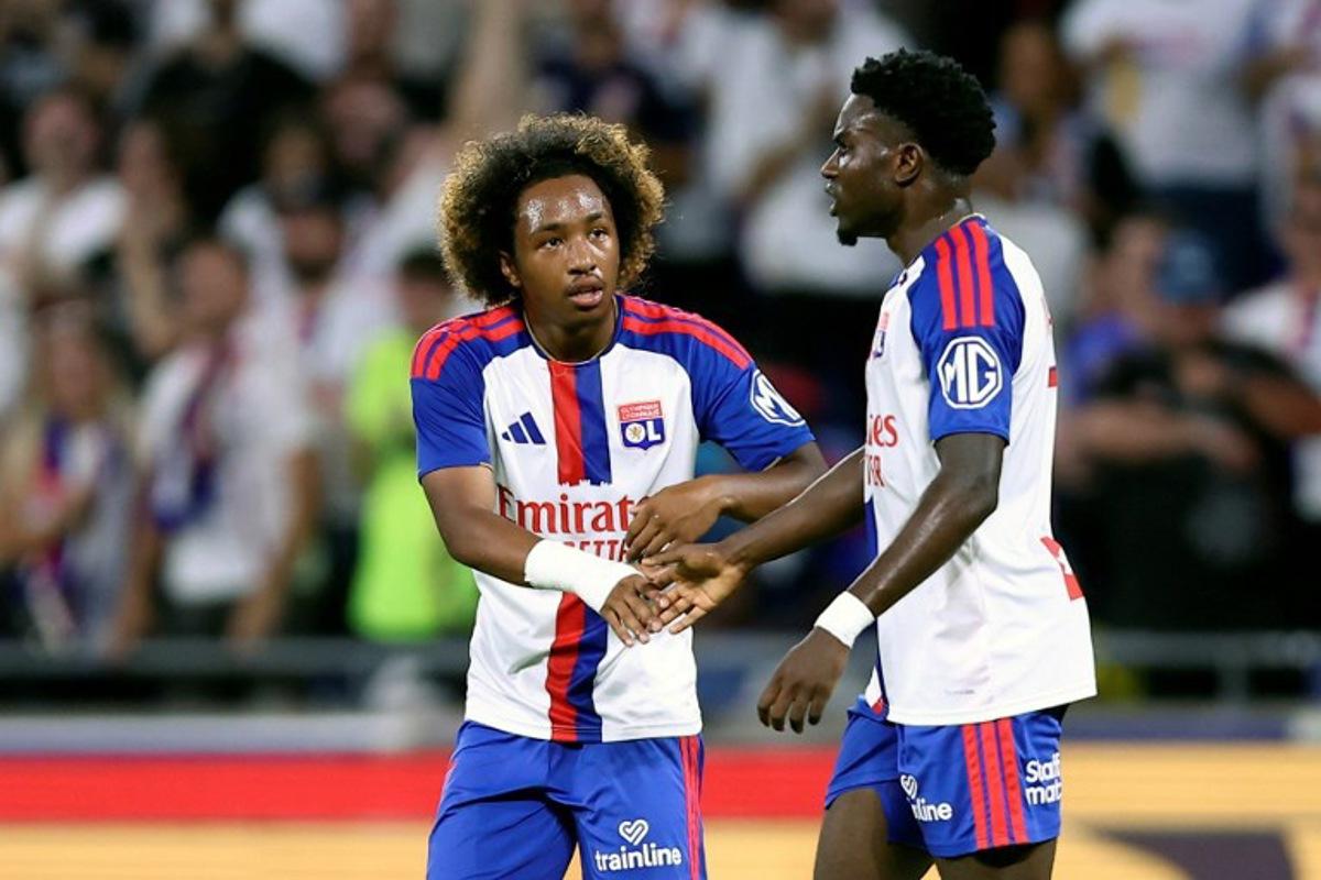 Lyon's Ghanaian forward #7 Ernest Nuamah (R) celebrates with Lyon's Belgian forward #11 Malick Fofana (C) after scoring his team's first goal during the UEFA Champions League third qualifying round - second leg football match between Olympique Lyonnais (OL) and Sparta Prague at Groupama Stadium in Decines-Charpieu, central-eastern France on August 11, 2026. Alex MARTIN / AFP