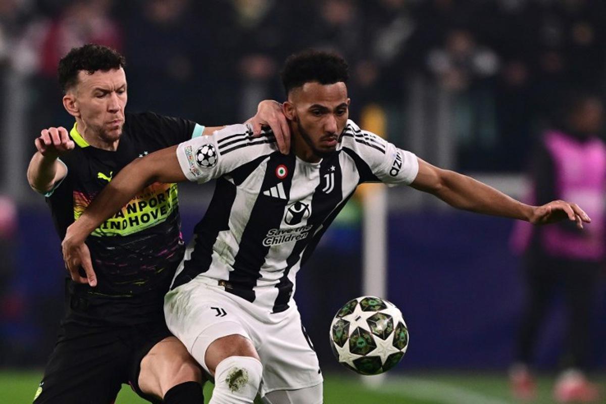 Juventus' British defender #06 Lloyd Kelly (R) fights for the ball with PSV Eindhoven's Croatian forward #05 Ivan Perisic during the UEFA Champions League knockout phase play-off 1st leg football match between Juventus and PSV Eindhoven at the Allianz stadium in Turin, on February 11, 2025. Marco BERTORELLO / AFP