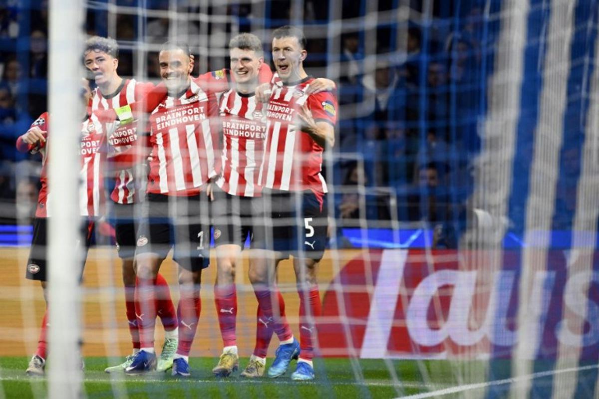 PSV Eindhoven's Dutch midfielder #20 Guus Til (2R) celebrates with teammates after scoring the opening goal during the UEFA Champions League first round day 3 football match between FC Porto and PSV Eindhoven at Dragao stadium in Porto, on October 20, 2026 Miguel RIOPA / AFP