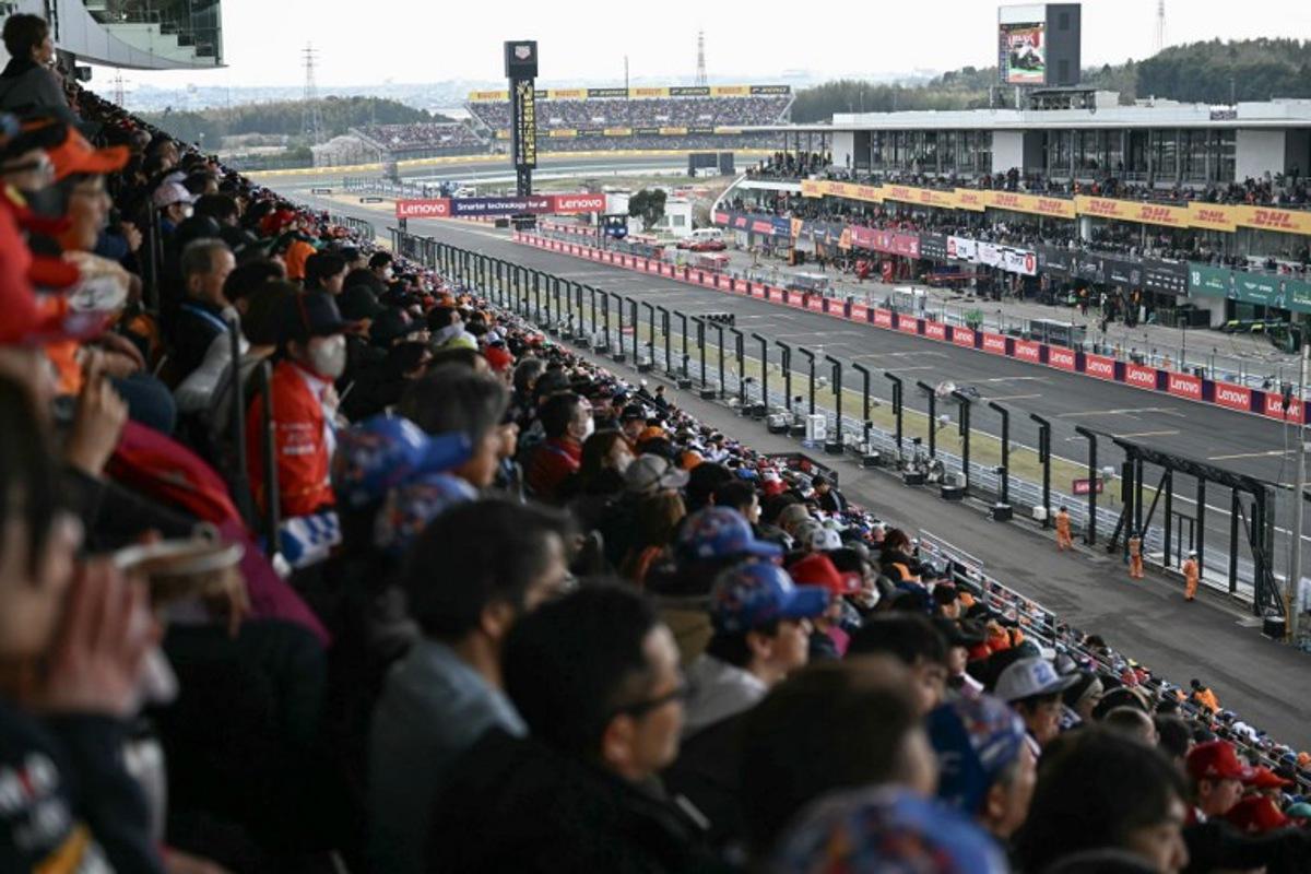 Fans watch Ferrari's British driver Lewis Hamilton drives during the Formula One Japanese Grand Prix at the Suzuka circuit in Suzuka, Mie prefecture, Japan on April 6, 2025. MOHD RASFAN / AFP