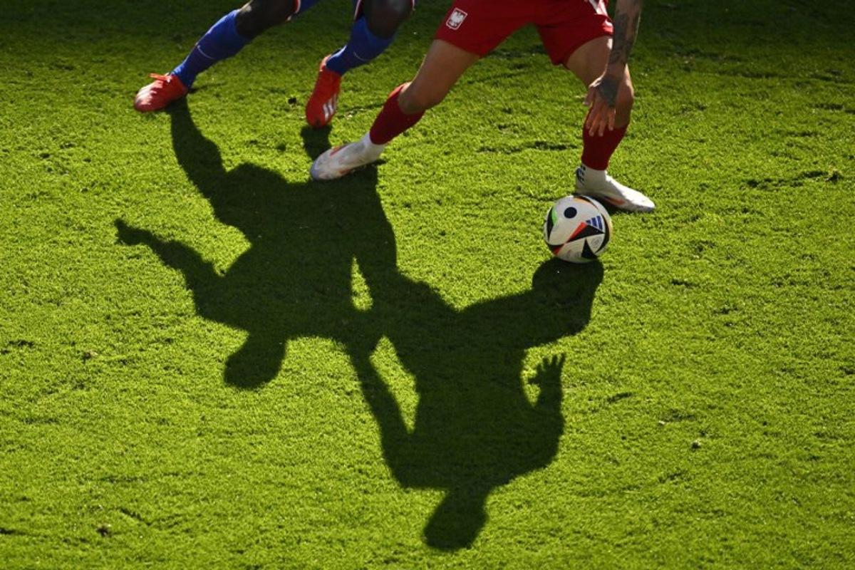 Shadows of players are cast on the pitch as they vie for the ball during the UEFA Euro 2024 Group D football match between France and Poland at the BVB Stadion in Dortmund on June 25, 2024. INA FASSBENDER / AFP