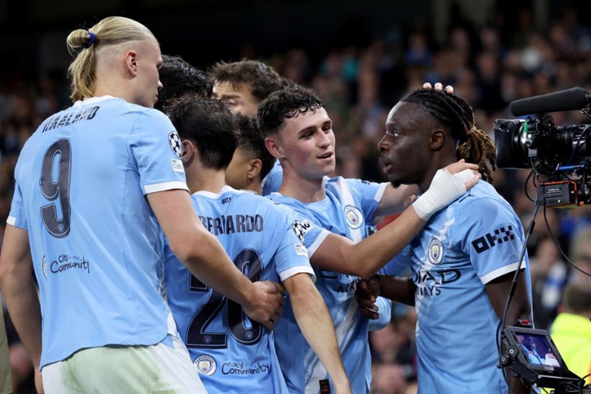 Manchester City's Belgian midfielder #11 Jeremy Doku (R) celebrates with teammates after scoring his team's second goal during the UEFA Champions League league stage football match between Manchester City and Napoli at the Etihad Stadium in Manchester, north west England, on September 18, 2025. Darren Staples / AFP