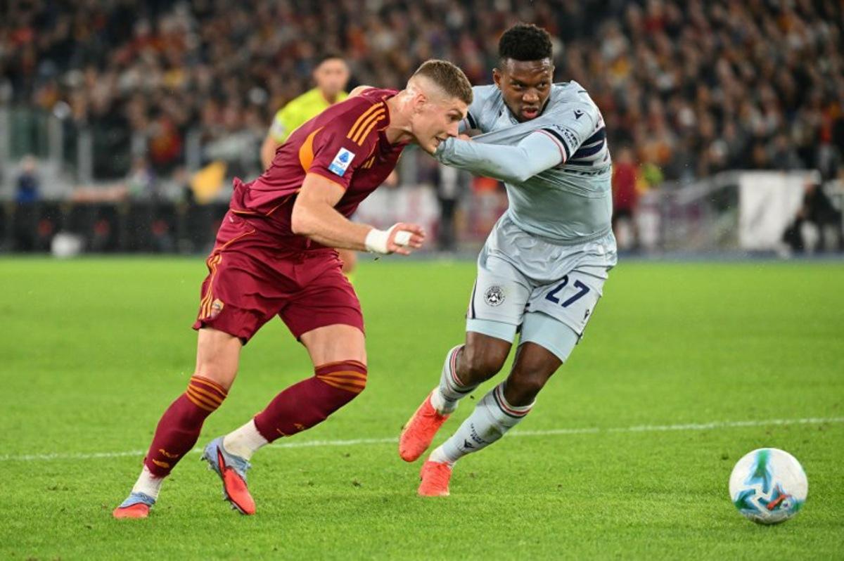 Roma's Ukrainian forward #09 Artem Dovbyk fights for the ball with Udinese's Belgian defender #27 Christian Kabasele during the Italian Serie A football match between AS Roma and Udinese at the Olympic Stadium in Rome on November 9, 2025. Alberto PIZZOLI / AFP