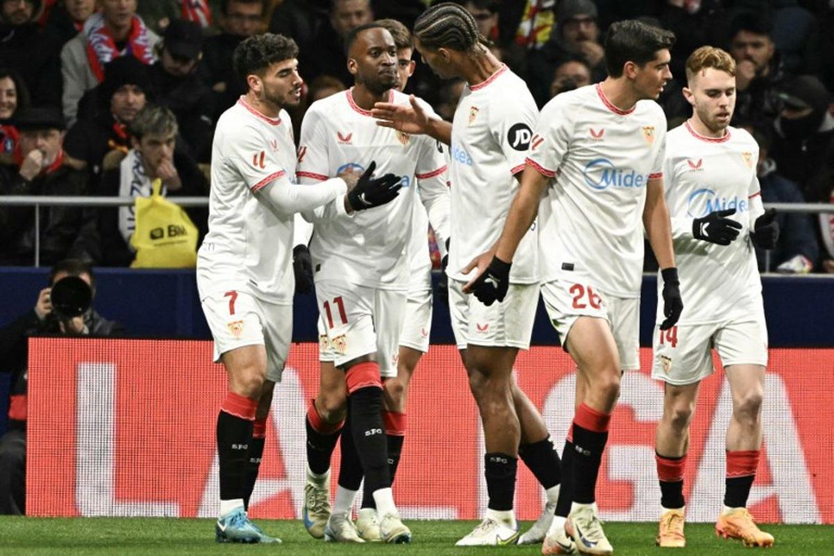 Sevilla's Belgian forward #11 Dodi Lukebakio (2L) celebrates after scoring their first goal during the Spanish league football match between Club Atletico de Madrid and Sevilla FC at the Metropolitano stadium in Madrid on December 8, 2024. JAVIER SORIANO / AFP