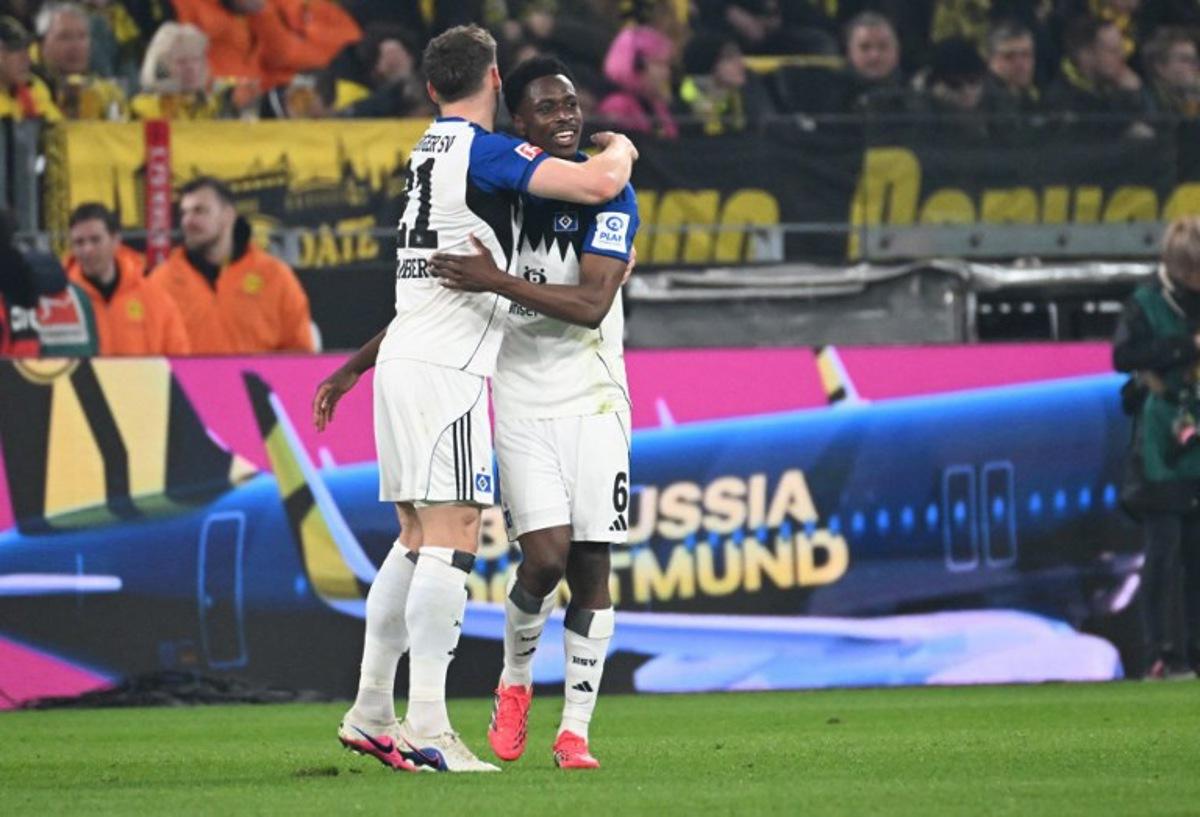 Hamburg's Belgian-Congolese midfielder #06 Albert Sambi Lokonga (R) celebrates his 0-2 during the German first division Bundesliga football match between Borussia Dortmund and HSV Hamburg in Dortmund, western Germany, on March 21, 2026. UWE KRAFT / AFP