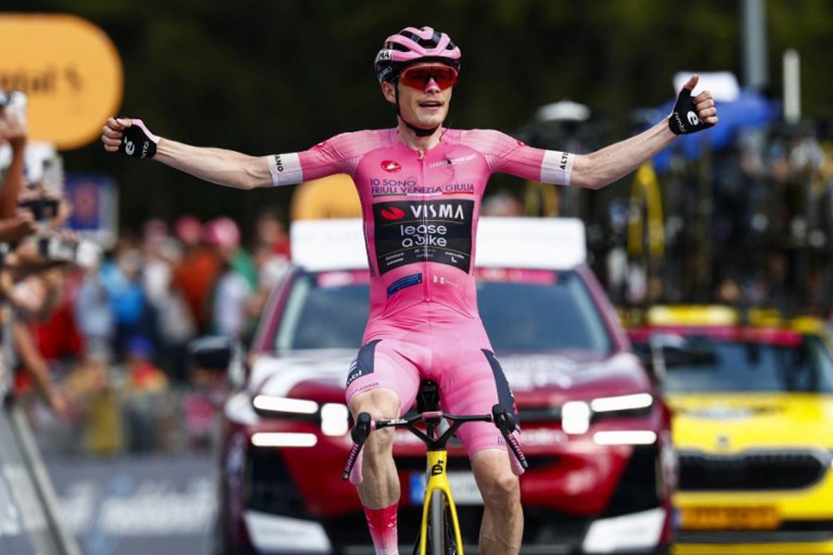 Team Visma Lease a Bike Danish rider Jonas Vingegaard wearing the overall leader's pink jersey (Maglia Rosa) celebrates as he crosses the finish line to win the 16th stage of the Giro d'Italia 2026 - Tour of Italy cycling race between Bellinzona and Cari, Switzerland, on May 26, 2026. Luca Bettini / AFP