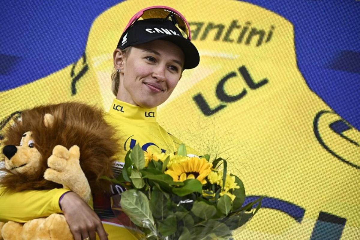 Canyon//SRAM Racing team's Polish rider Katarzyna Niewiadoma celebrates on the podium wearing the overall leader's yellow jersey after winning the third edition of the Women's Tour de France cycling race and competing in the 8th and last stage of the Women's Tour de France cycling race, a 149.9 km between Le Grand Bornand and the Alpe d'Huez, in L'Alpe d'Huez, south-eastern France, on August 18, 2024. JULIEN DE ROSA / AFP